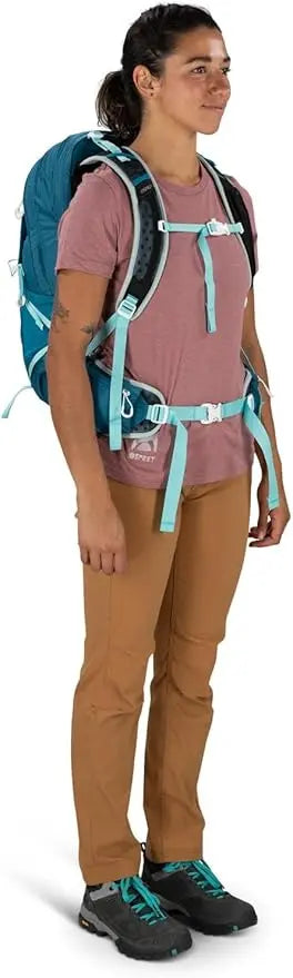 Person wearing Osprey Talon Earth 22 men's hiking daypack, showcasing its fit and design on a hiking trail.
