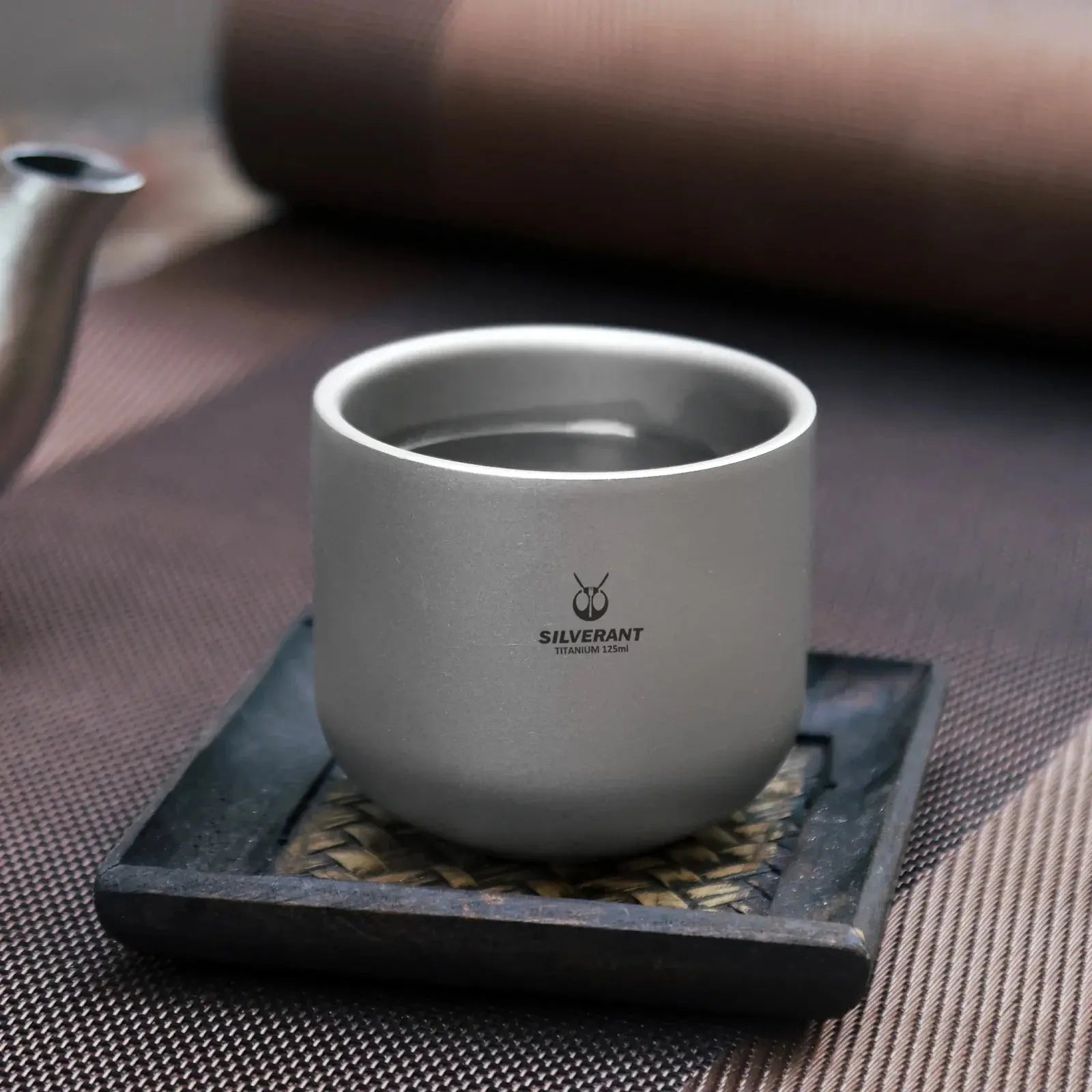 SilverAnt Titanium Tea Cup Double Wall - 4 oz resting on a desert camping rock