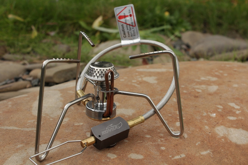Kovea Spider Stove compact remote canister camping gas burner on rock surface