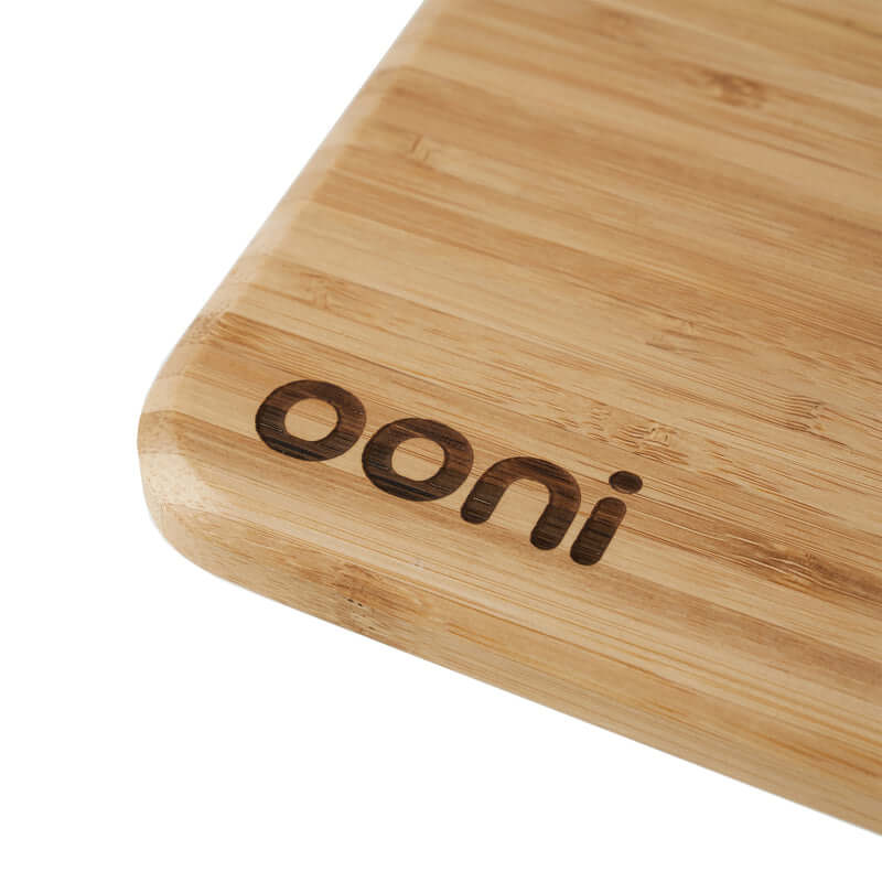 Close-up of Ooni Pizza Prep Lid bamboo board with logo engraving.