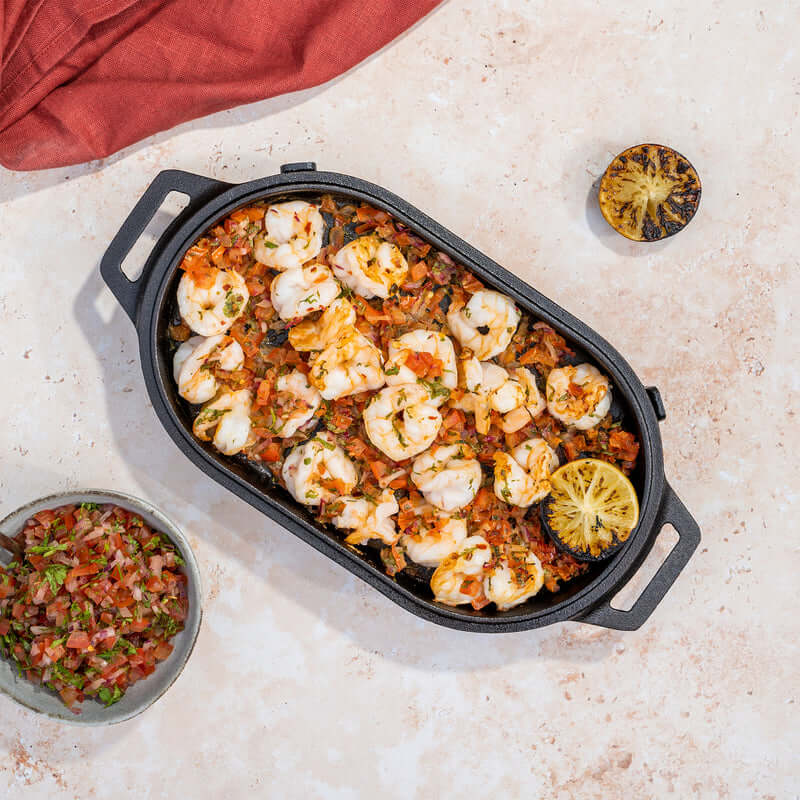 Ooni Cast Iron Sizzler Pan sizzling meat over open flame in UAE
