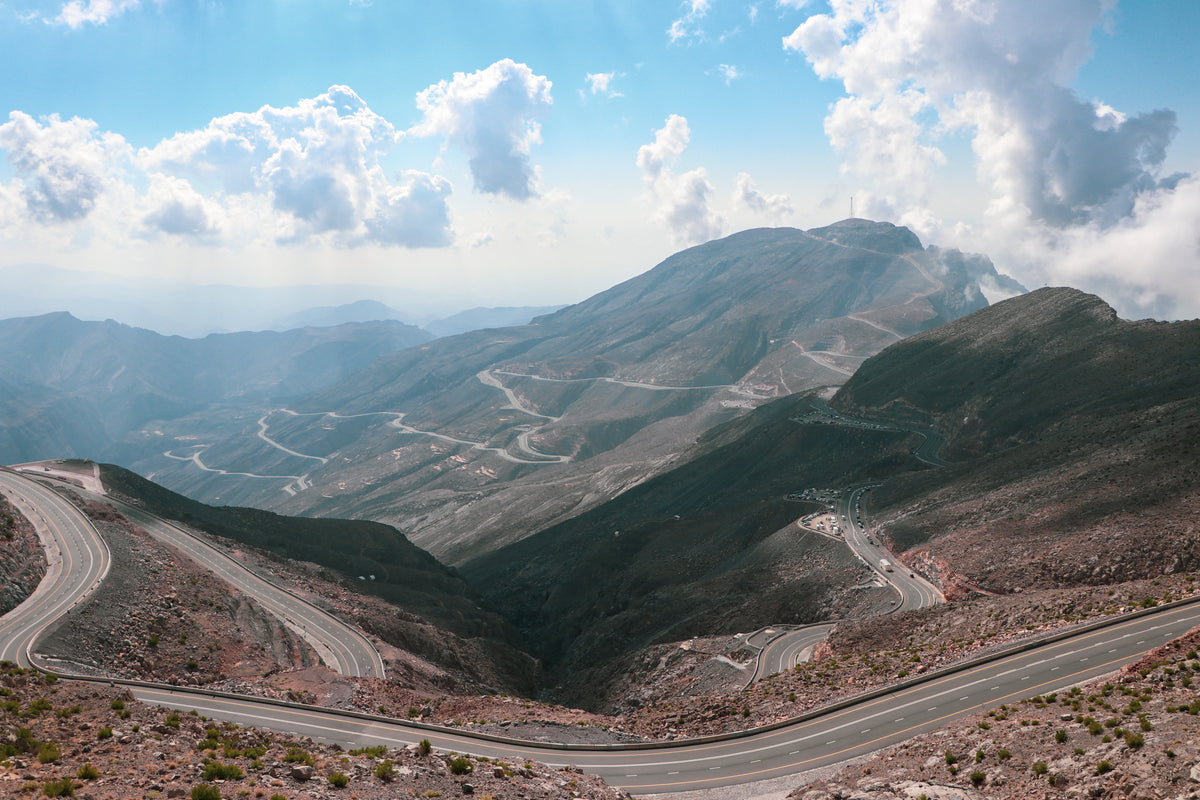 Jebel Jais mountain in the UAE road with a clear blue sky and clouds