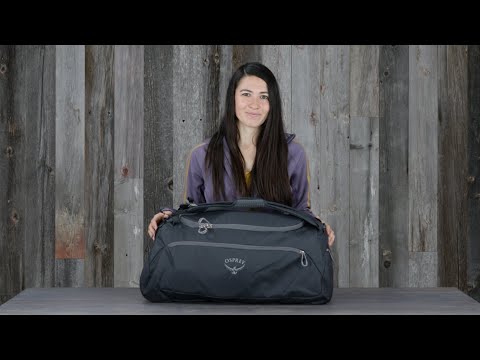 Load video: Osprey Daylite Duffel 30 versatile bag with backpack, shoulder and grab-and-go options shown by woman against wooden background