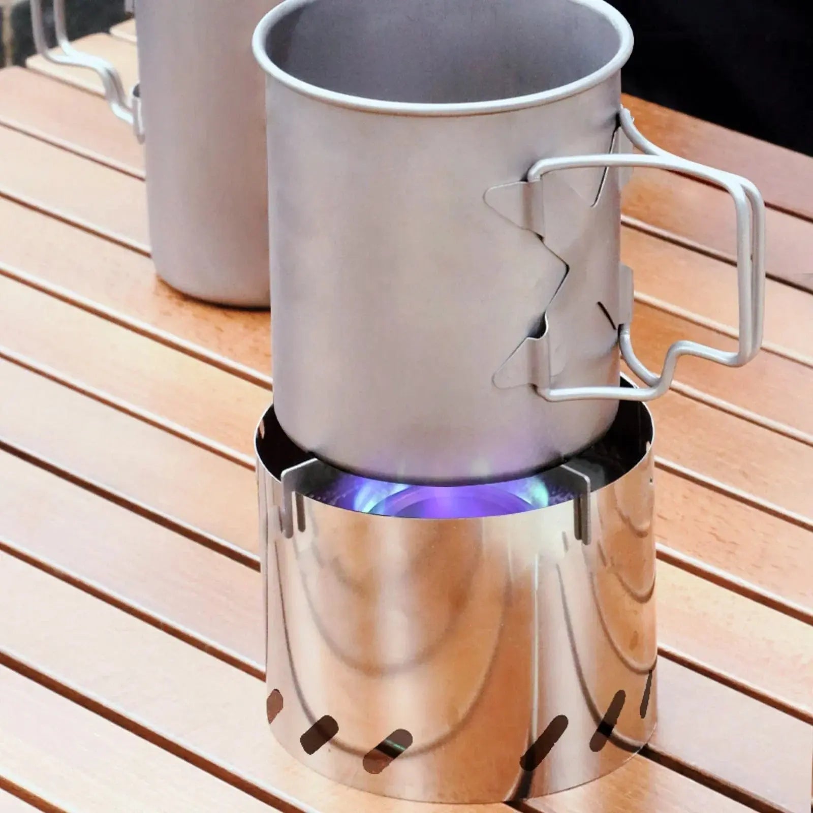 SilverAnt Ultralight Titanium Stove Cross Stand and Windshield in use outdoors on a wooden table.