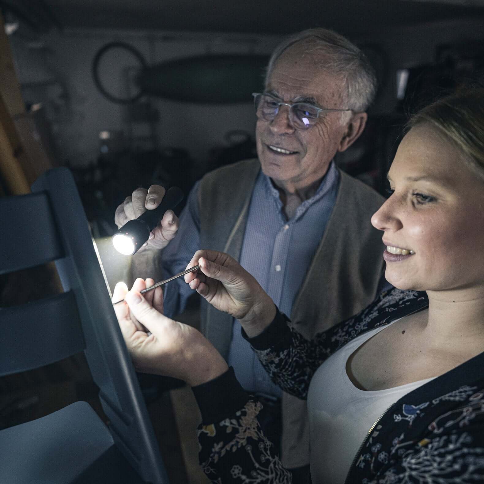 P6R flashlight illuminating a repair project with a man and woman in a workshop.