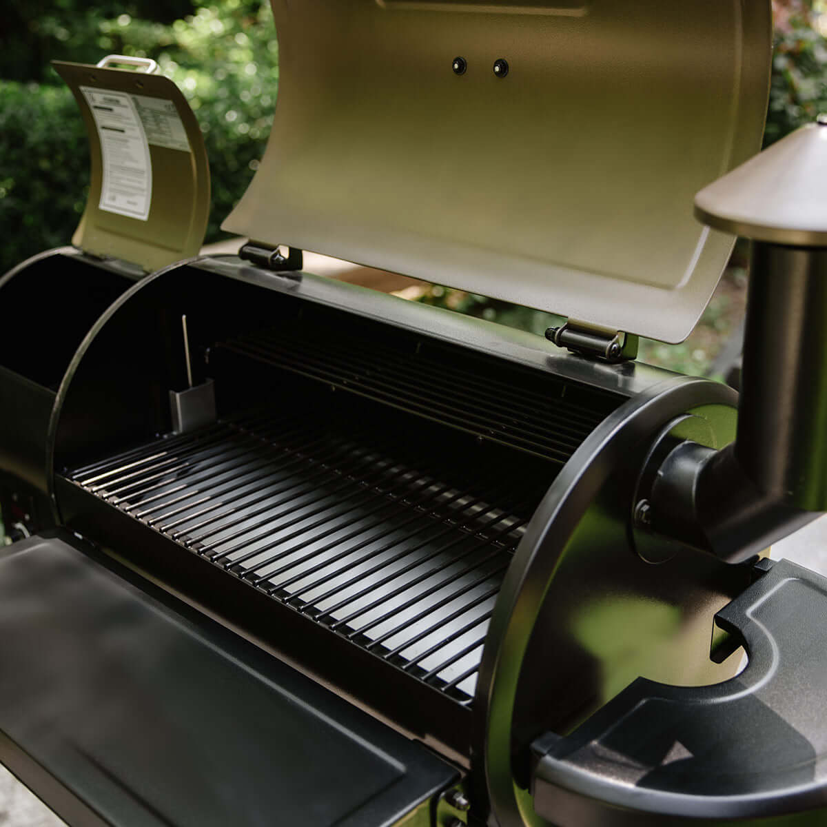 Open Z Grills Wood Pellet Grill and Smoker 450A showing grilling area in a backyard setting