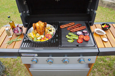 Campingaz Culinary Modular Poultry Roaster on a barbecue grill with vegetables and sausages, perfect for outdoor cooking.