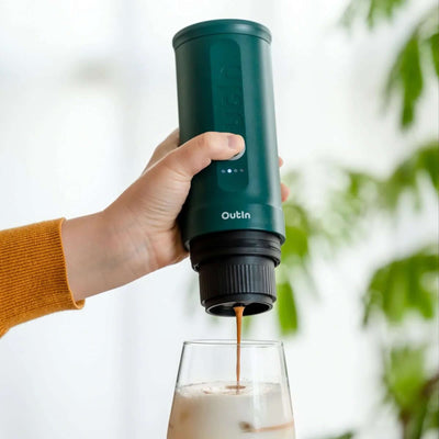 Outin Nano Portable Espresso Machine - Teal being put on glass