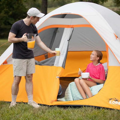 Family enjoying time inside a 3 Person Dome Backpacking Tent - 7' x 7' with orange accents.