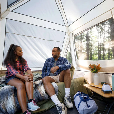 6 Person Lighted Instant Pyramid Tent - 12' x 7' interior view with two people relaxing in a spacious and cozy setup.