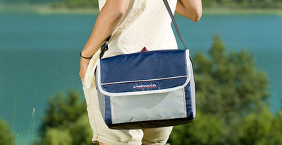 Person carrying a Campingaz Fold'N Cool Cooler Bag near a scenic outdoor location, ideal for UAE adventures.