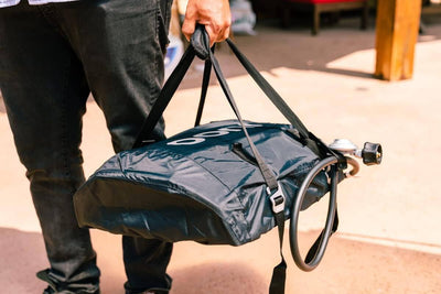 Person carrying Ooni Carry Cover for Ooni Koda 12, showcasing portability and protection for outdoor cooking appliances.