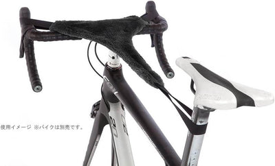 A black fuzzy handlebar tape cover draped over bicycle drop handlebars, shown on a white background with part of the bike frame and saddle visible.