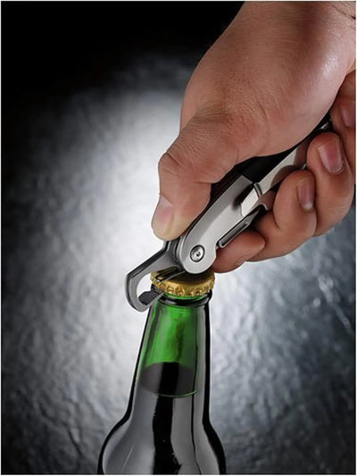 Leatherman C33 folding pocket knife opening a bottle cap during outdoor use.