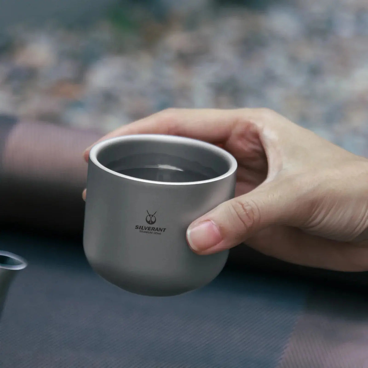 Adventurer holding the SilverAnt Titanium Tea Cup Double Wall - 4 oz during a UAE mountain hike