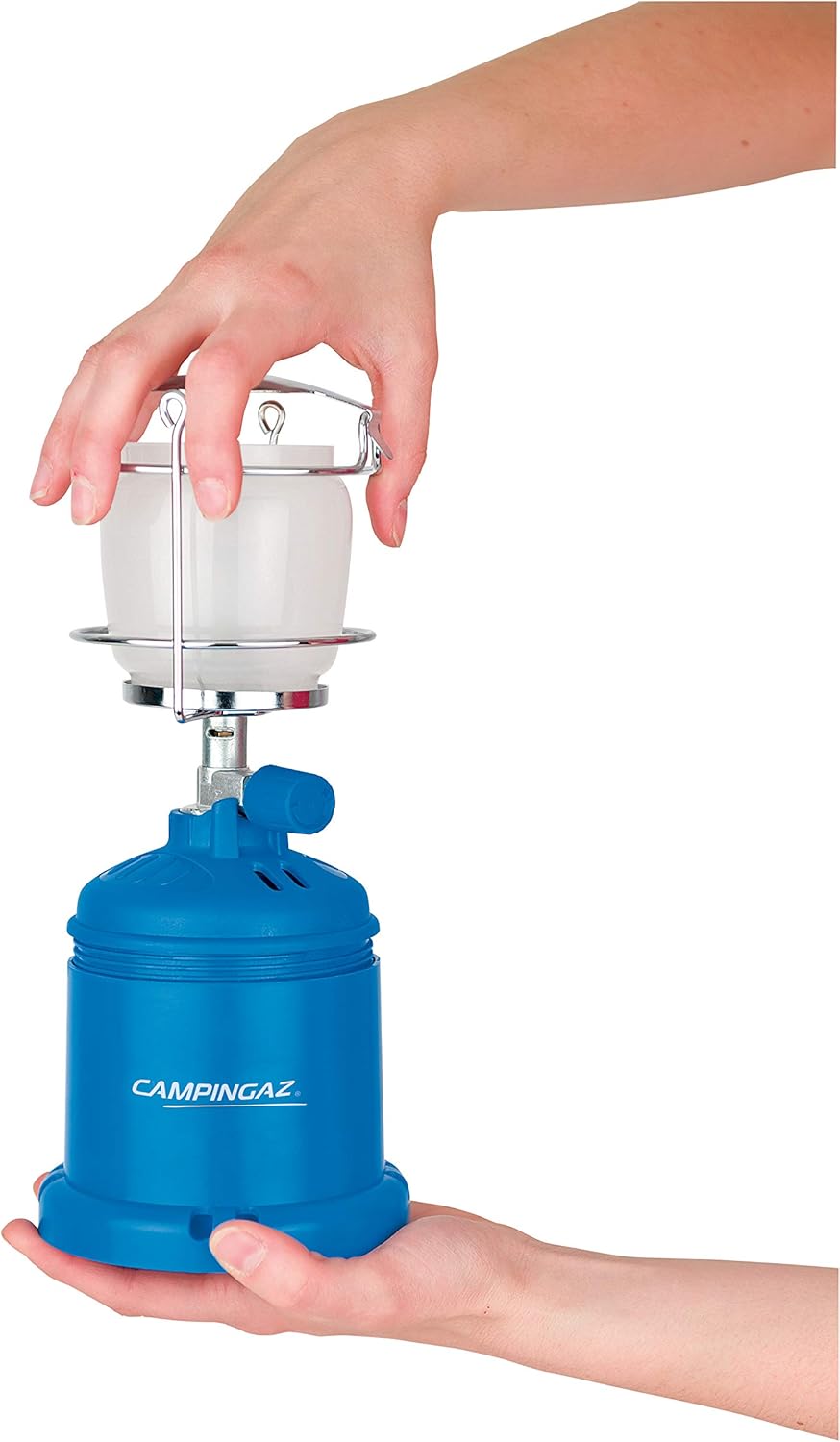 Holding the Campingaz 206L Gas Lantern, a compact camping light for outdoor adventures.