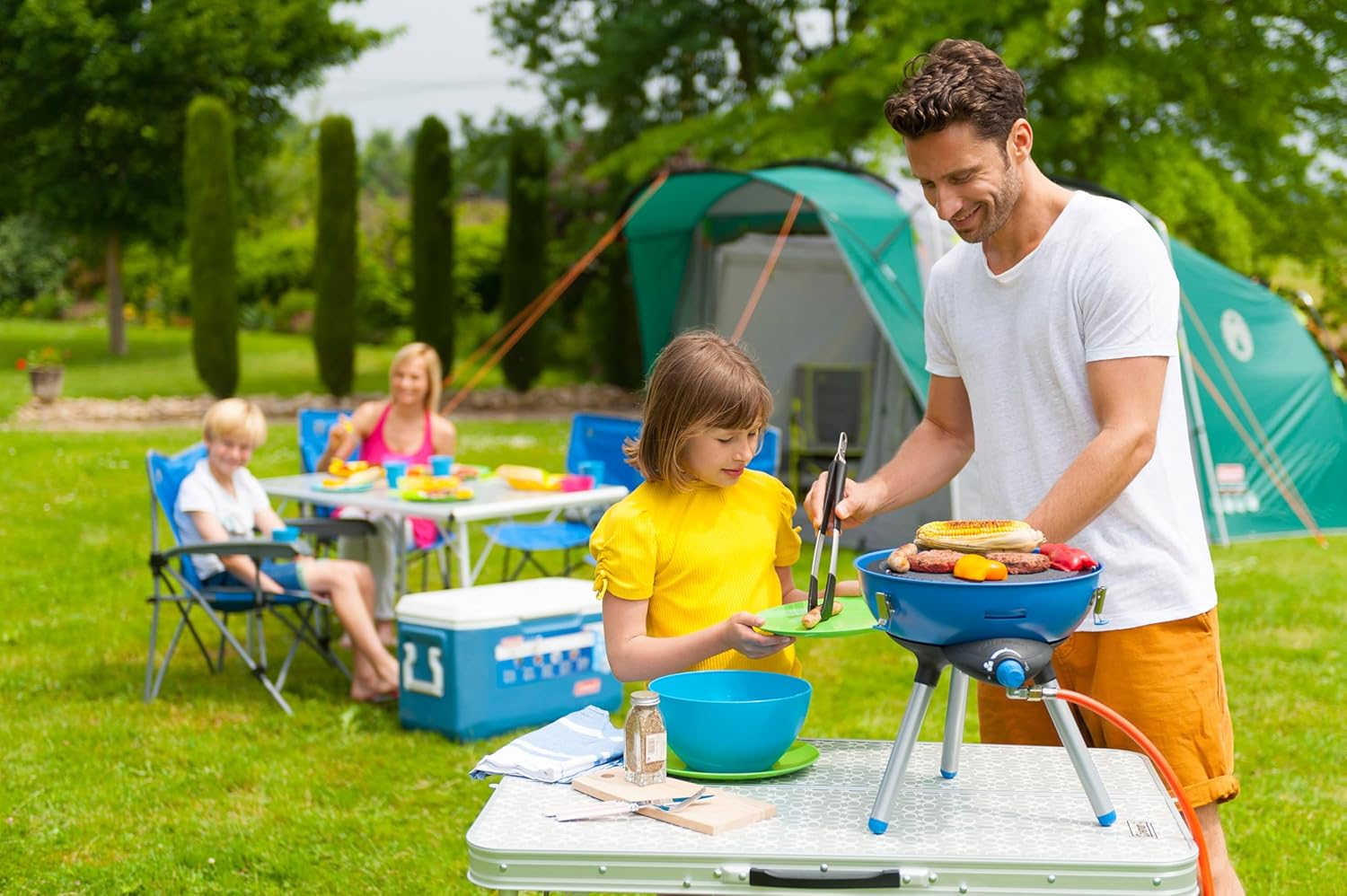 Father and daughter grilling outdoors with Campingaz Party Grill 400 at a family picnic