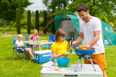 Father and daughter grilling outdoors with Campingaz Party Grill 400 at a family picnic