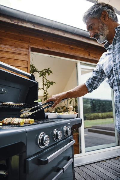 Man grilling food on Campingaz 3 Series Premium S Gas Grill on terrace