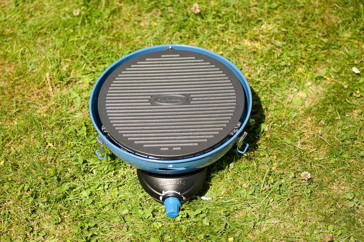 Campingaz Party Grill 400 placed on grass, ideal for outdoor cooking adventures in various UAE landscapes.