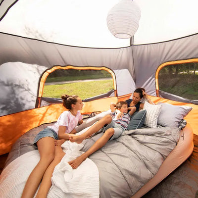 Family relaxing inside a tent on a spacious Core Equipment 40 Degree Double Cool Climate queen sleeping bag, perfect for couples or solo use.