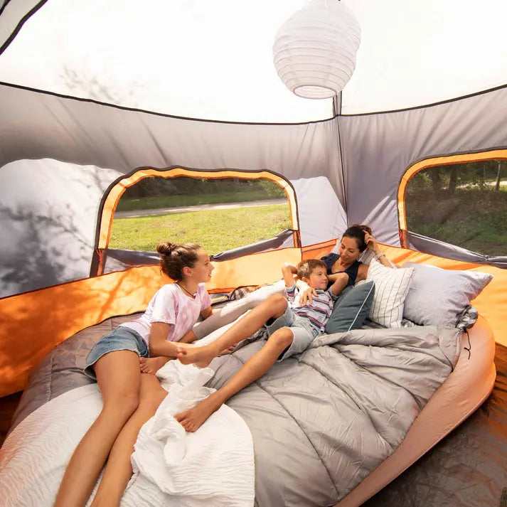 Family relaxing inside a tent on a spacious Core Equipment 40 Degree Double Cool Climate queen sleeping bag, perfect for couples or solo use.