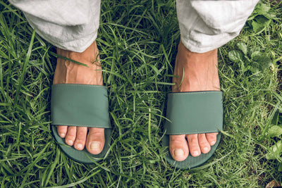 Feet wearing Indosole Slides recycled tire sole sandals on grass