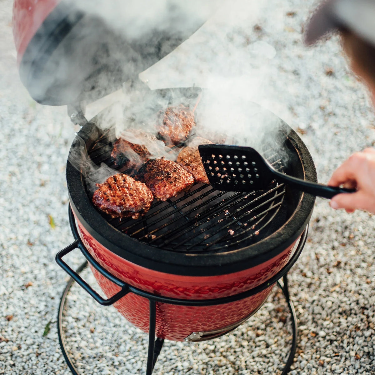 Kamado Joe Joe Jr. with Cast Iron Stand being used to grill
