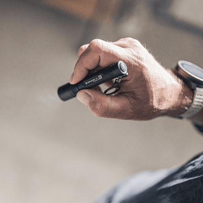 P3 tiny key flashlight held in hand showing focusable beam and sleek design.