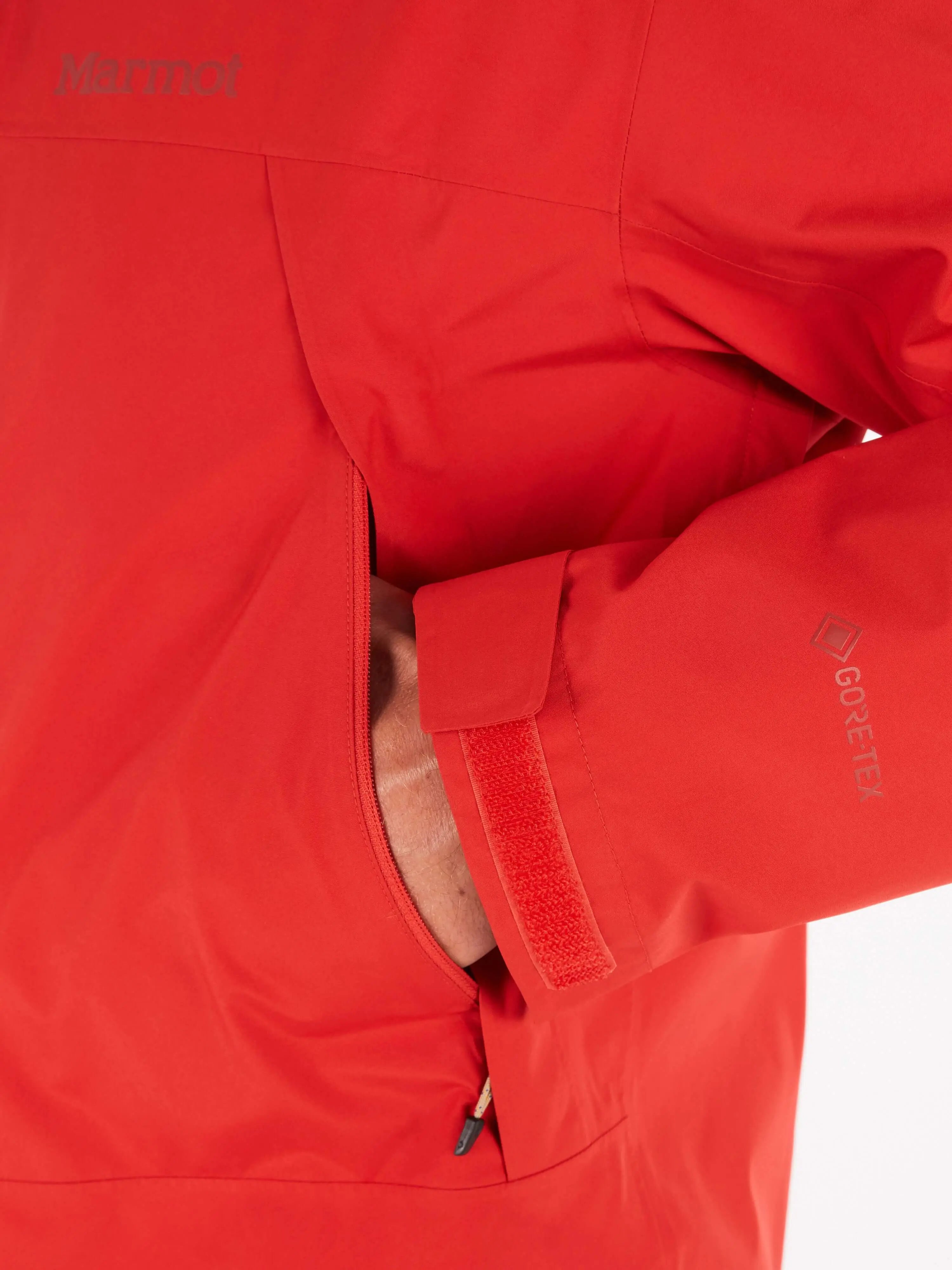 Close-up of Marmot Gore-Tex Minimalist Pro Jacket showcasing waterproof fabric and adjustable cuff on a red men's shell jacket.