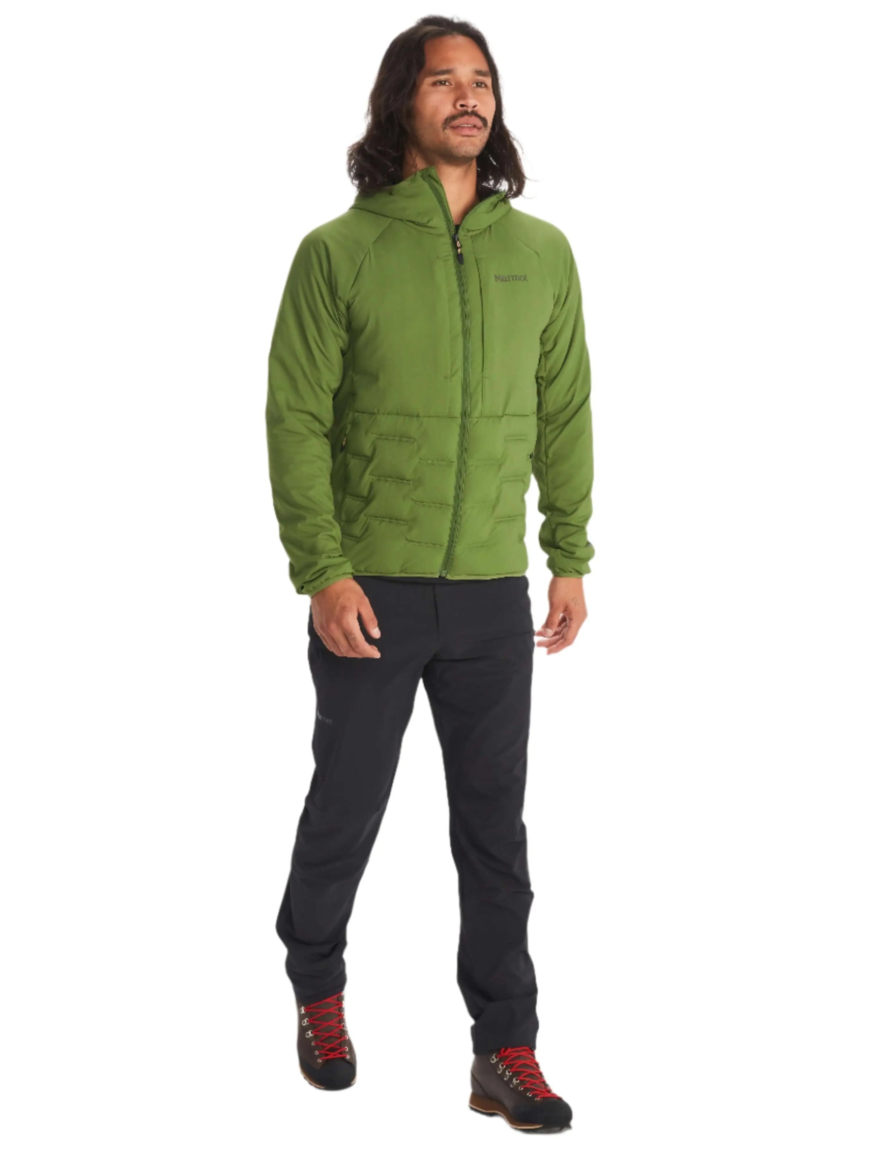 Man wearing Marmot Warmcube Men's Winter Jacket in green, standing outdoors ready for adventure.