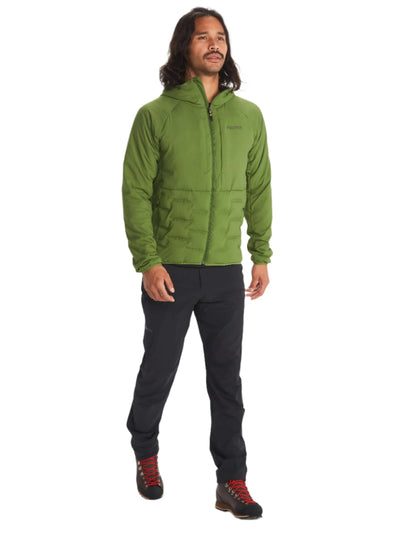 Man wearing Marmot Warmcube Men's Winter Jacket in green, standing outdoors ready for adventure.