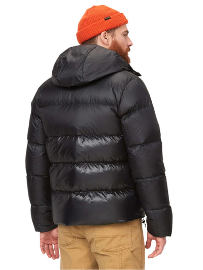 Back view of a man wearing Marmot Guides Down Hoody men's insulated jacket in black with orange beanie.