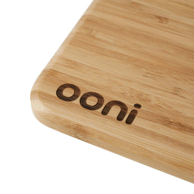 Close-up of Ooni Pizza Prep Lid bamboo board with logo engraving.