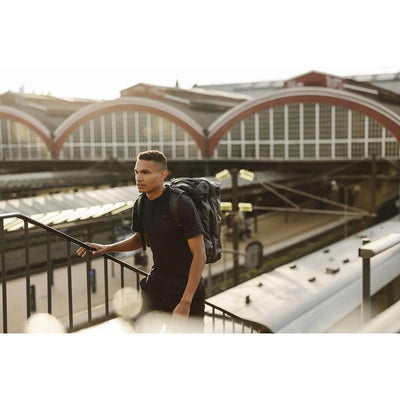 Man walking with a rugged Transporter Squffel 44 backpack in an urban setting.