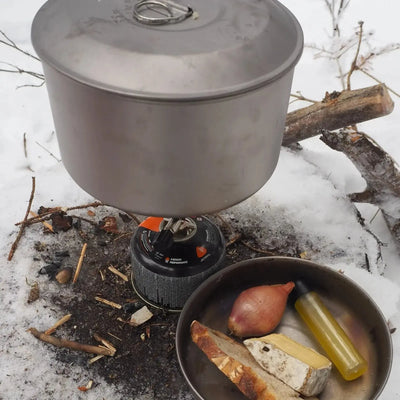 SilverAnt Titanium Camping Cookware Set 1.6L with food ingredients on snow, perfect for outdoor adventures.