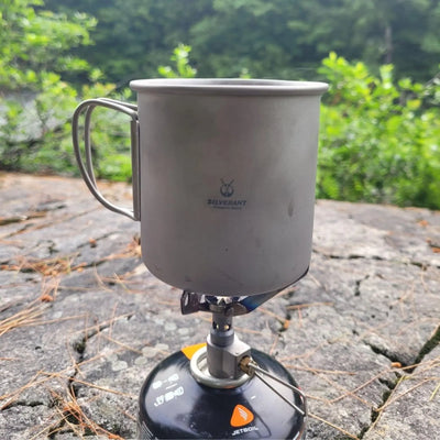 SilverAnt Ultralight Titanium Cup with Lid resting on a portable camp stove