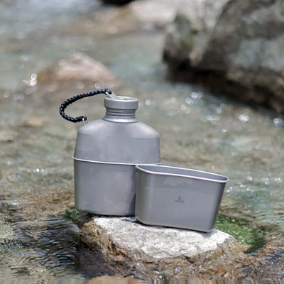 SilverAnt Titanium Canteen Military Mess Kit by a rocky stream, ideal for outdoor adventures.