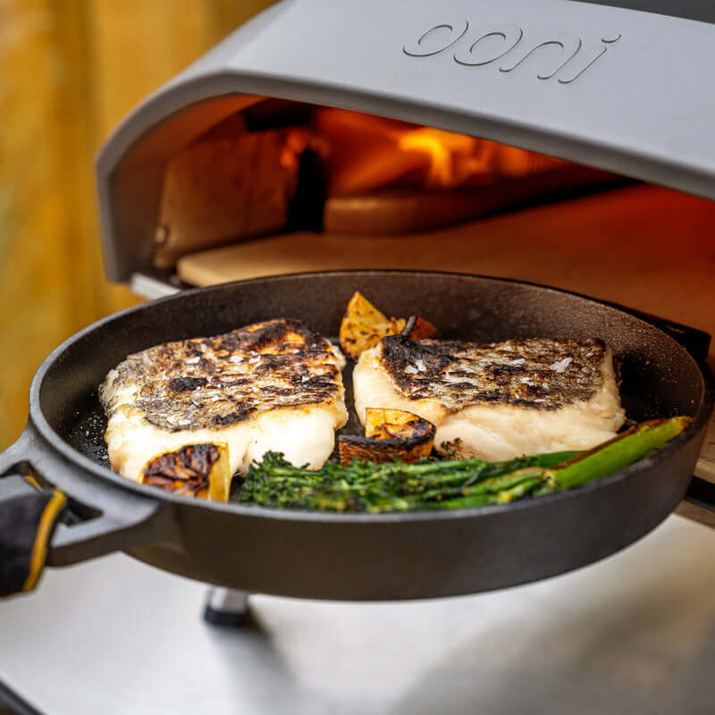 Ooni Cast Iron Skillet Pan searing a thick steak over a UAE campfire