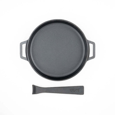 Top-down view of the Ooni Cast Iron Skillet Pan resting on its wooden serving board