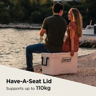 Couple sitting on Coleman Xtreme Marine 70Qt cooler with Have-A-Seat lid by the sea