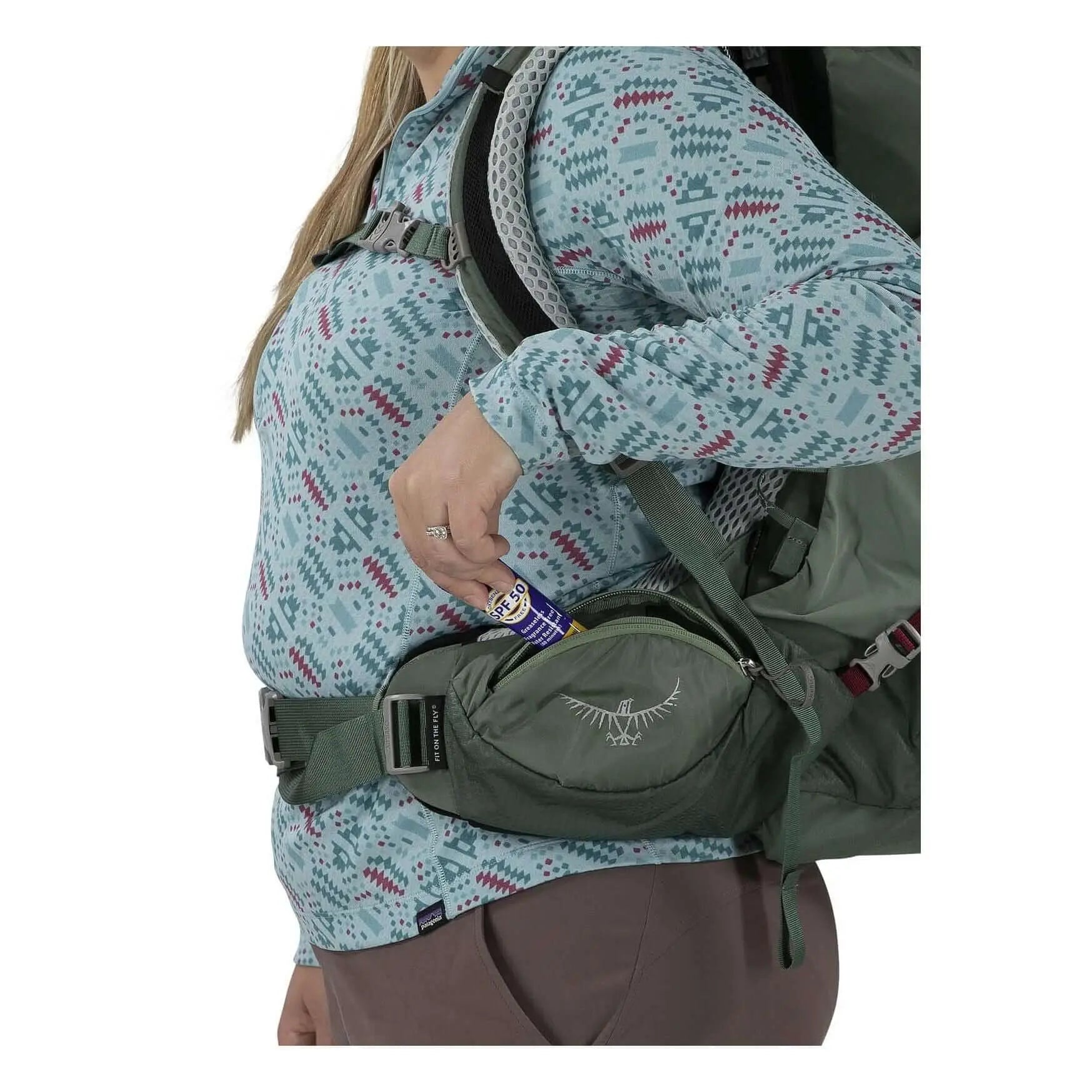 Woman using Osprey Aura AG LT 50 backpack side pocket, showcasing lightweight, ventilated design for technical backpackers.
