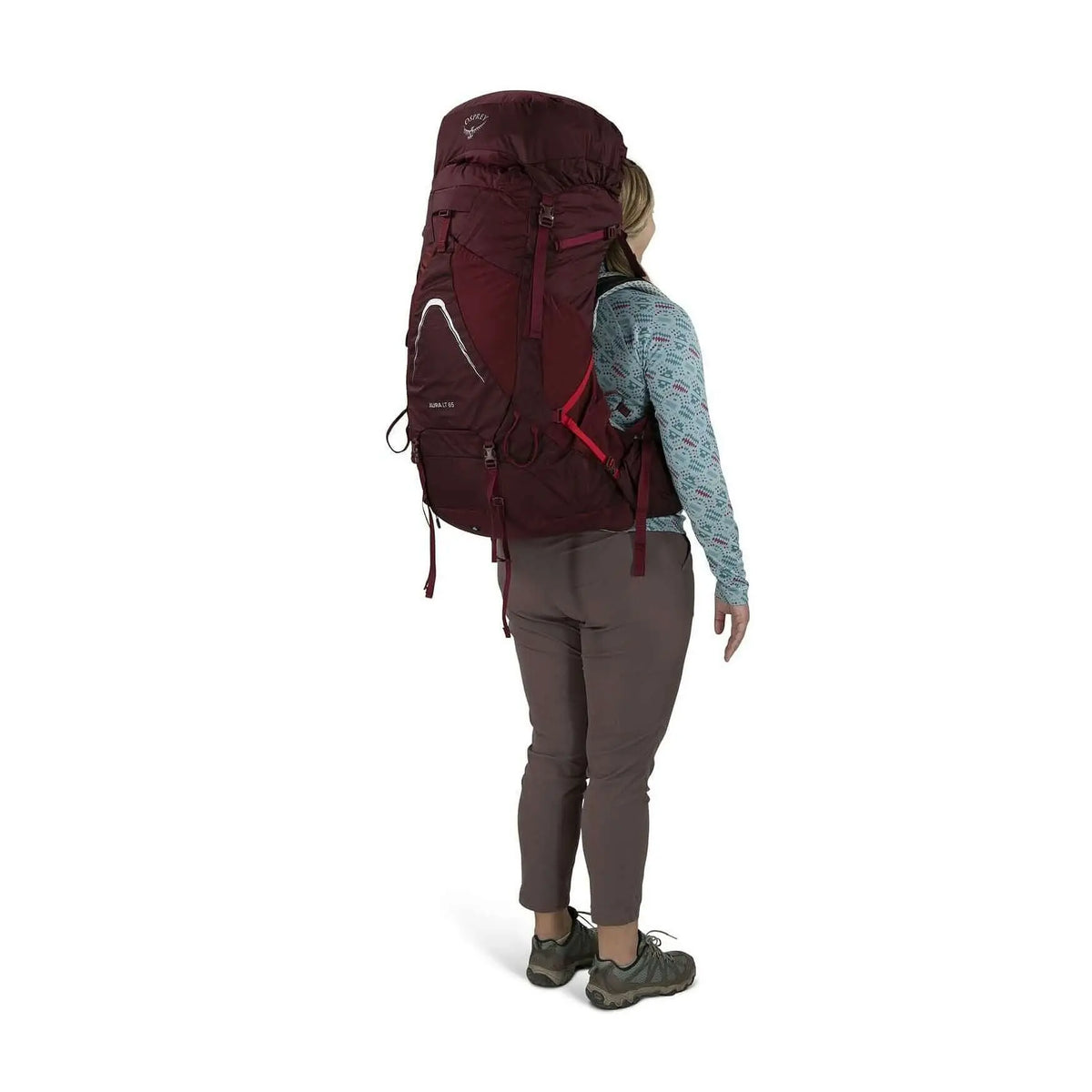 Woman wearing Osprey Aura AG LT 65 backpack for women, showcasing lightweight design and comfort for backcountry adventures.