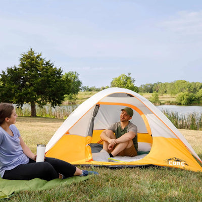 3 Person Dome Backpacking Tent - 7' x 7' set up by a lake with two people relaxing inside.