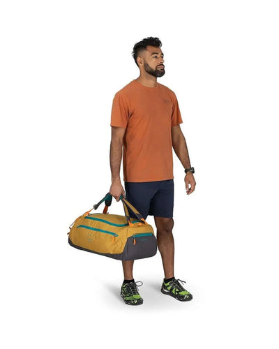 Man holding Osprey Daylite Duffel 45 with padded bottom and easy-access pockets, showcasing versatile carrying options for sports and travel.
