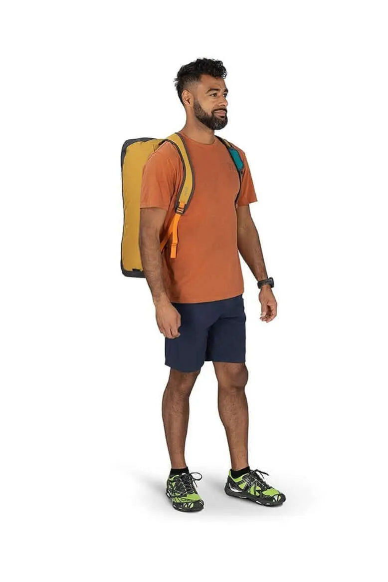 Man carrying Osprey Daylite Duffel 45 in backpack mode, showcasing versatile carry options and ease of use.