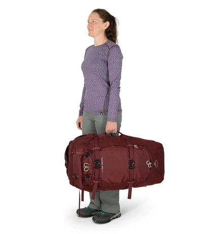 Woman carrying Fairview Trek 70 - Women backpack in maroon color for travel and adventure.