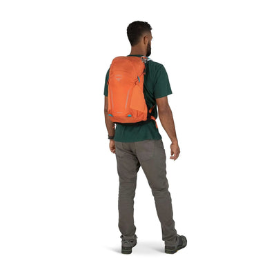 Hiker wearing Osprey Hikelite 18 daypack with AirSpeed ventilation, showcasing lightweight and streamlined design for outdoor adventures.