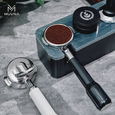 Muvna E61 Double Spout Portafilter - 58mm on countertop, showcasing coffee grounding and barista tools, ideal for home coffee brewing enthusiasts.