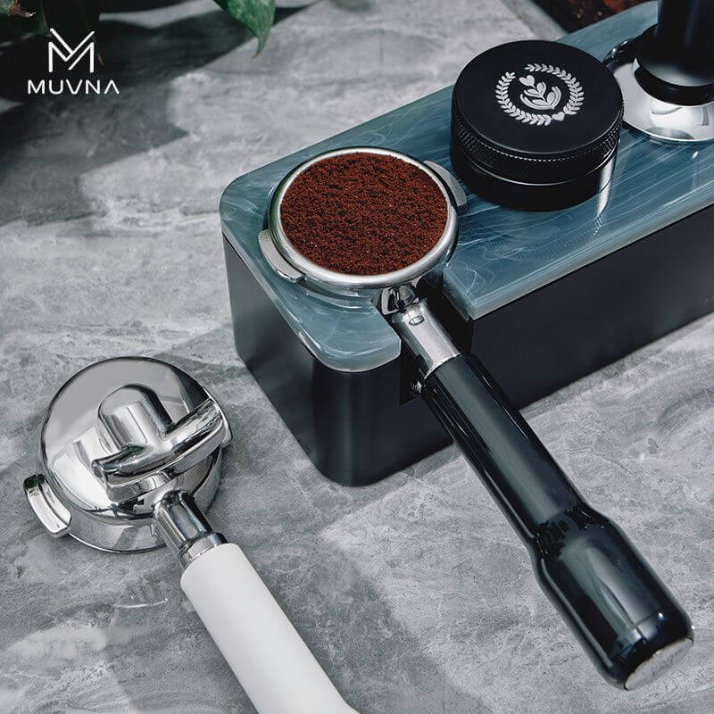 Muvna E61 Double Spout Portafilter - 58mm on countertop, showcasing coffee grounding and barista tools, ideal for home coffee brewing enthusiasts.